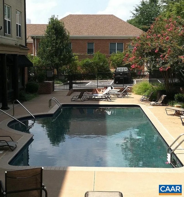 community pool featuring a patio and fence