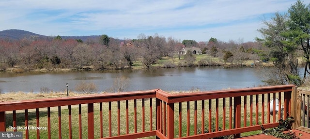 wooden terrace featuring a water view and a lawn