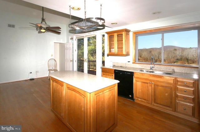 kitchen with black dishwasher, a sink, a center island, and brown cabinets