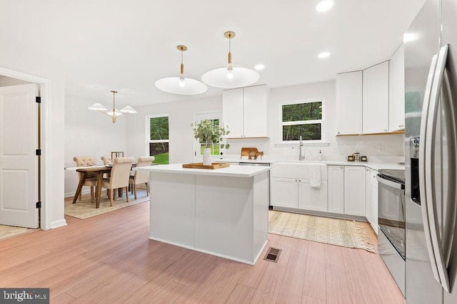 228 Poplar Dr, Louisa, VA 23093 - kitchen featuring stainless steel fridge, range with electric stovetop, a sink, light countertops, and white cabinetry