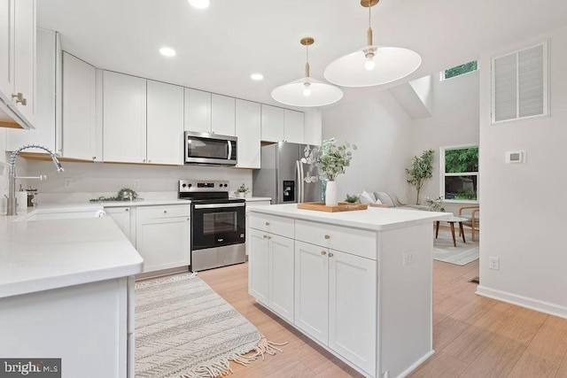 228 Poplar Dr, Louisa, VA 23093 - kitchen featuring appliances with stainless steel finishes, a sink, light wood-style floors, light countertops, and white cabinets
