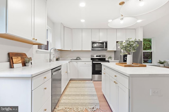 228 Poplar Dr, Louisa, VA 23093 - kitchen with stainless steel appliances, a sink, white cabinetry, a kitchen island, and light wood finished floors
