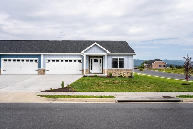 view of front of property with a garage, a mountain view, and a front yard