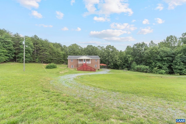 3590 Mountain Hill Rd, Palmyra, VA 22963 - view of green lawn with driveway, a forest view, and a deck