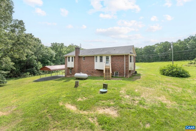 3590 Mountain Hill Rd, Palmyra, VA 22963 - rear view of house with brick siding, a chimney, a detached carport, and a lawn