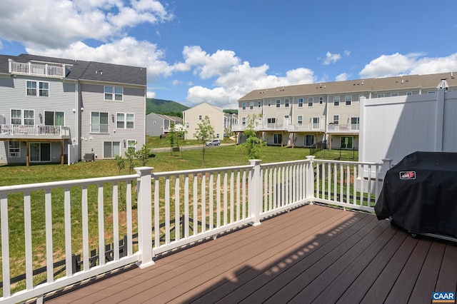 wooden terrace featuring a residential view, a yard, a grill, and central AC unit