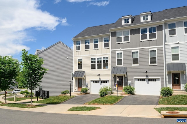 view of property featuring board and batten siding, driveway, and an attached garage