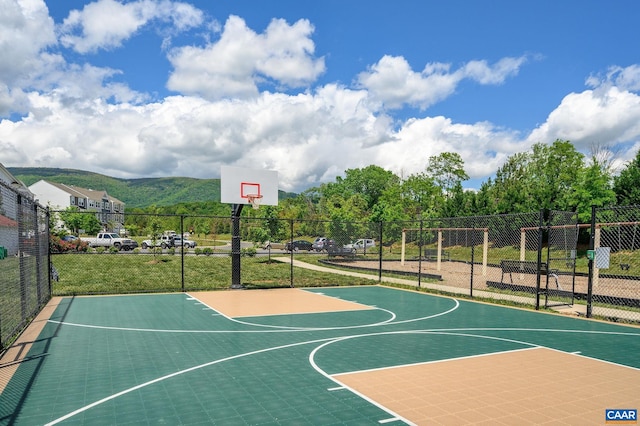 view of basketball court with community basketball court and fence