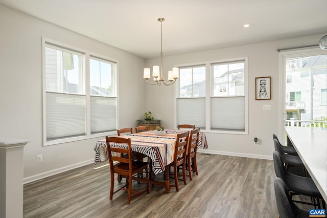 dining room featuring a chandelier, wood finished floors, baseboards, and recessed lighting