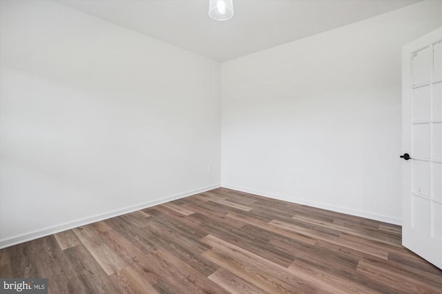 spare room featuring wood finished floors and baseboards