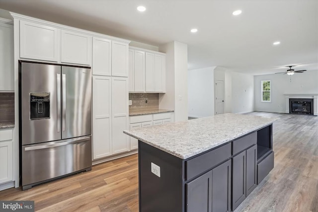kitchen with stainless steel fridge with ice dispenser, white cabinets, a ceiling fan, light wood-style floors, and recessed lighting