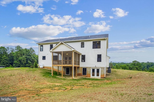 rear view of house with french doors, a yard, and a deck