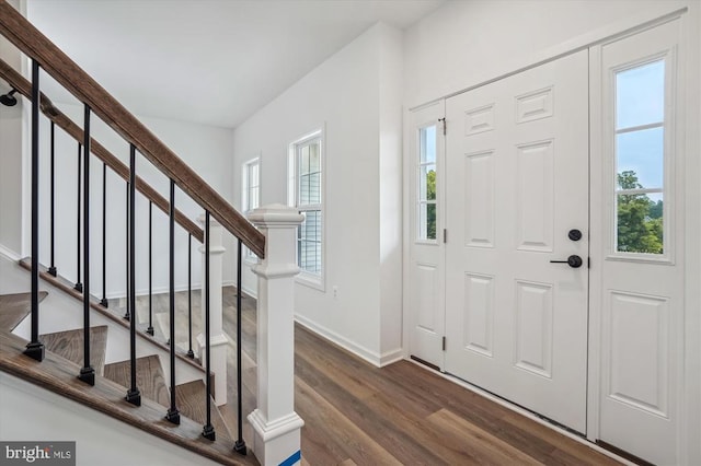entrance foyer featuring dark wood-style floors, stairs, and baseboards