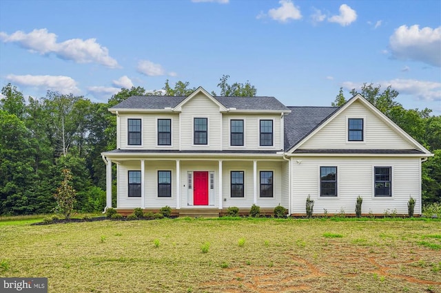 colonial home featuring covered porch, a front lawn, and roof with shingles