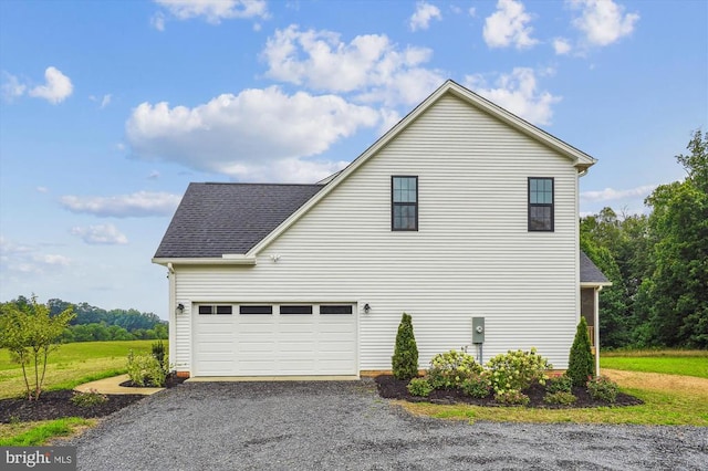 view of side of home featuring asphalt driveway, a garage, and a shingled roof