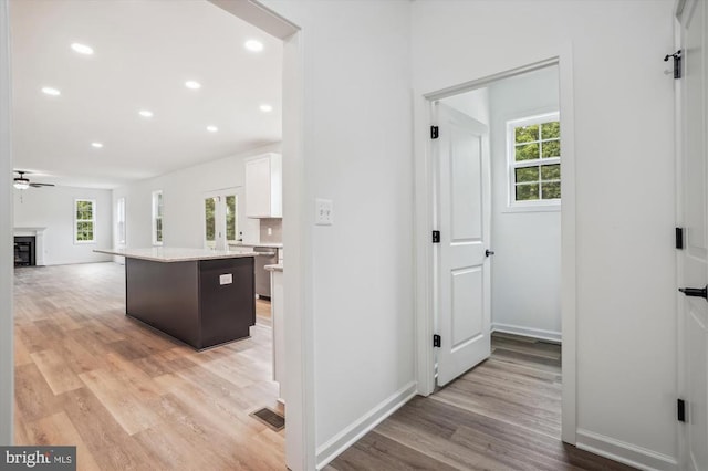 kitchen with healthy amount of natural light, light wood-style flooring, white cabinetry, a ceiling fan, and recessed lighting