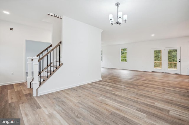 empty room with a chandelier, stairs, wood finished floors, recessed lighting, and baseboards