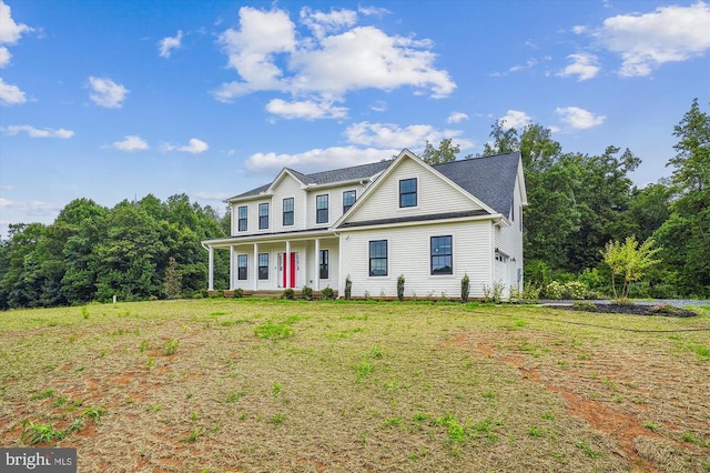 view of front facade featuring covered porch, a garage, and a front yard
