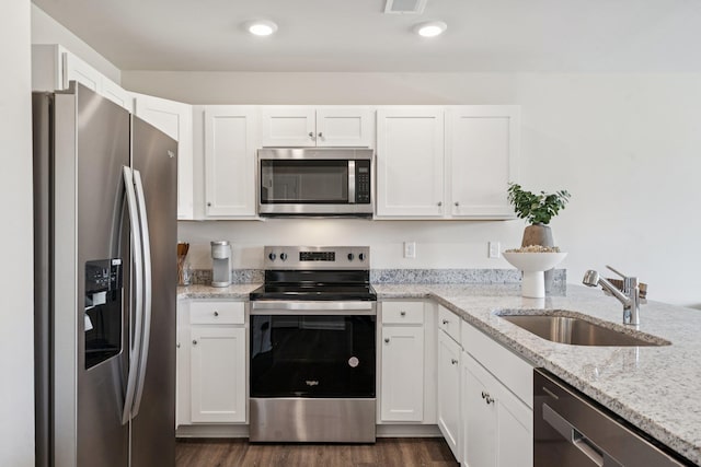228 Camden Dr, Waynesboro, VA 22980 - kitchen with appliances with stainless steel finishes, white cabinetry, light stone counters, dark wood finished floors, and recessed lighting