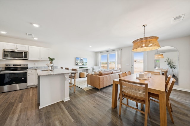 228 Camden Dr, Waynesboro, VA 22980 - dining space featuring arched walkways, dark wood-style floors, and recessed lighting