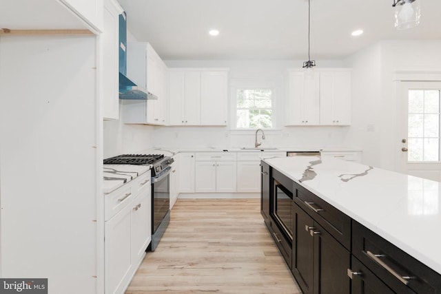 29 Dove Ct, Bumpass, VA 23024 - kitchen featuring stainless steel range with gas stovetop, white cabinets, wall chimney exhaust hood, light wood-type flooring, and recessed lighting