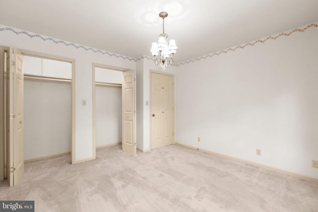 411 Laurel Ave, Fredericksburg, VA 22408 - unfurnished bedroom with multiple closets, a chandelier, and light colored carpet