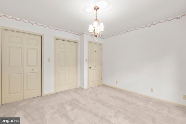 411 Laurel Ave, Fredericksburg, VA 22408 - unfurnished bedroom featuring a chandelier, light colored carpet, and two closets
