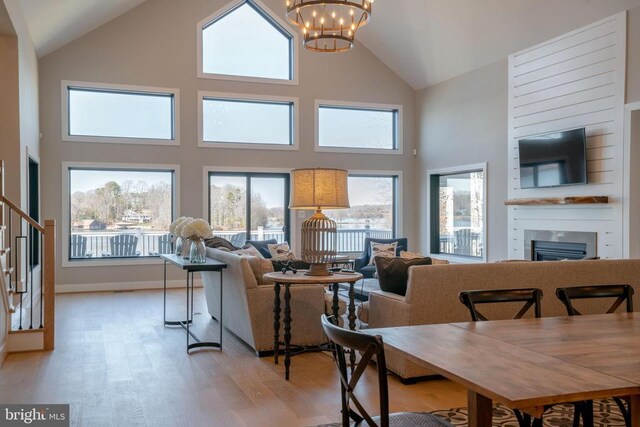 3 Carrs Bridge Rd, Lake Anna, Bumpass, VA 23024 - dining room featuring light wood finished floors, high vaulted ceiling, a chandelier, a fireplace, and stairway