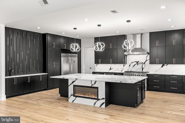 235 Sir Walter Dr, Bumpass, VA 23024 - kitchen featuring dark cabinets, built in refrigerator, visible vents, wall chimney range hood, and a spacious island
