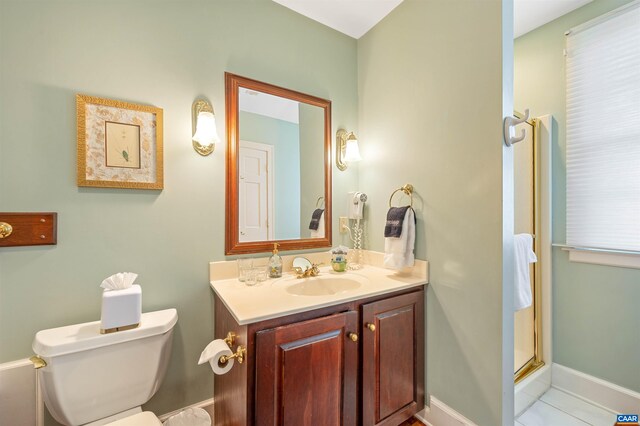 full bathroom featuring toilet, baseboards, vanity, and a stall shower
