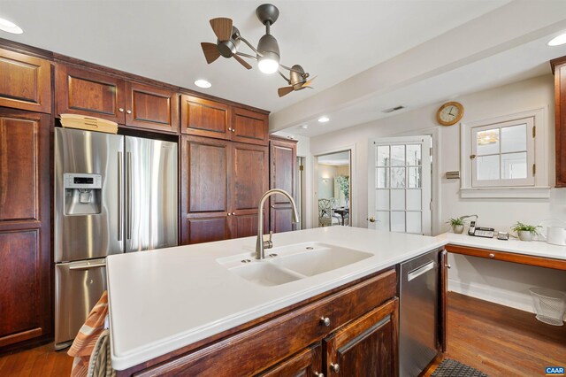 kitchen with a sink, recessed lighting, dark wood finished floors, light countertops, and appliances with stainless steel finishes