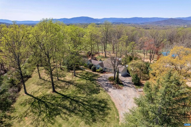 birds eye view of property featuring a wooded view and a mountain view