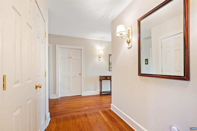 hall with baseboards and hardwood / wood-style floors