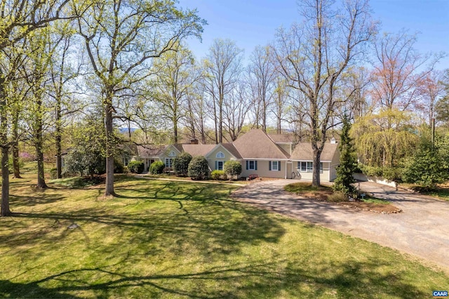 single story home featuring a chimney, dirt driveway, and a front yard