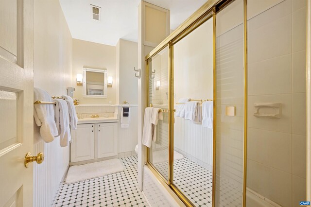 bathroom featuring tile patterned floors, vanity, visible vents, and a stall shower