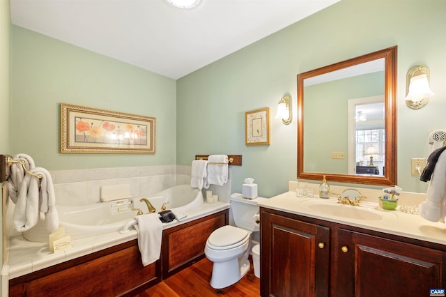 full bath featuring a bath, toilet, wood finished floors, and vanity