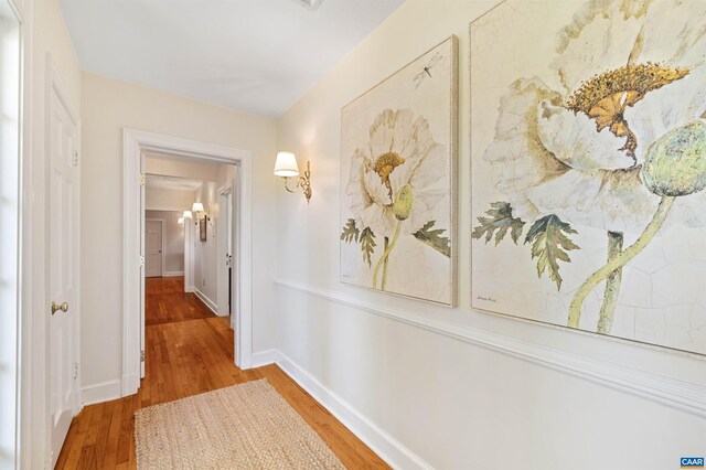 hallway with baseboards and wood finished floors