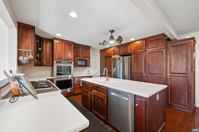 kitchen featuring a center island with sink, light countertops, and stainless steel appliances