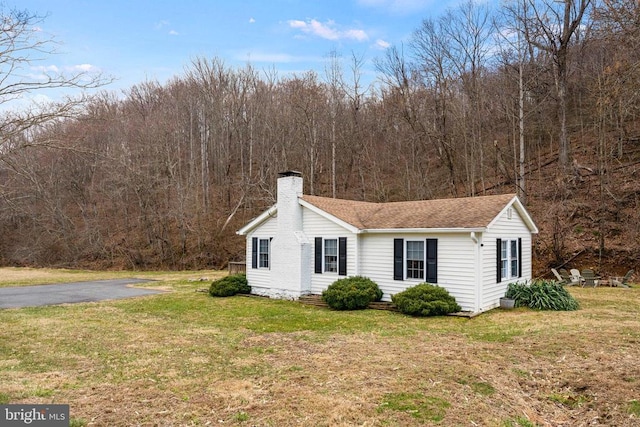 1195 Quaker Run Rd, Madison, VA 22727 - view of property exterior featuring a chimney, a yard, a view of trees, and a shingled roof
