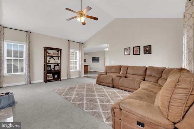 carpeted living area with ceiling fan, baseboards, and high vaulted ceiling