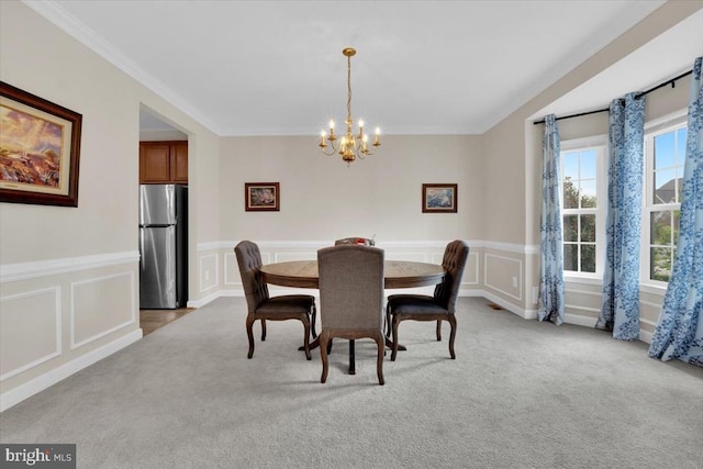 carpeted dining room featuring wainscoting, an inviting chandelier, ornamental molding, and a decorative wall