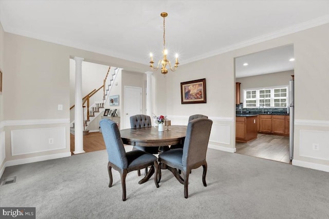 dining room featuring light colored carpet, a chandelier, visible vents, and ornamental molding