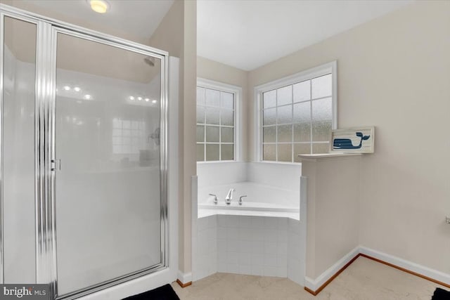 full bath with a stall shower, baseboards, and a bath