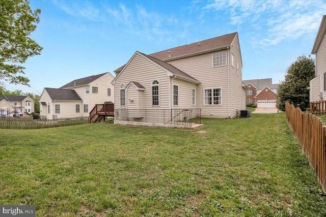 rear view of property featuring central air condition unit, a fenced backyard, a residential view, and a lawn