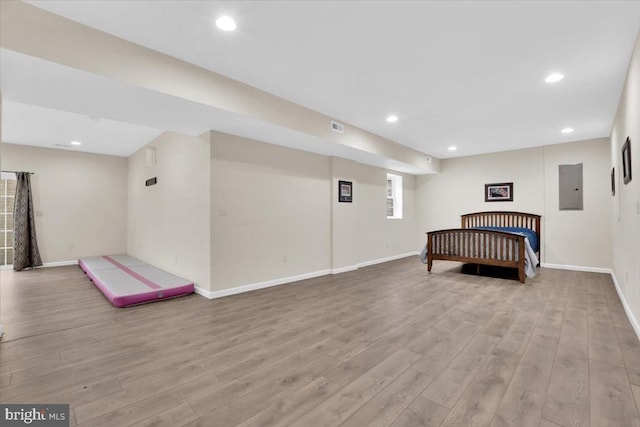 interior space featuring recessed lighting, baseboards, electric panel, and light wood-type flooring
