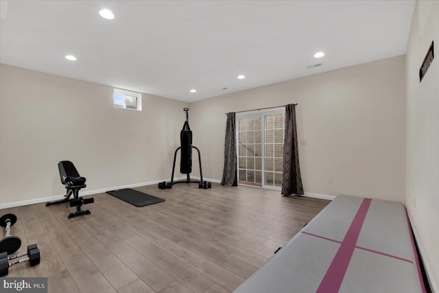 workout area with recessed lighting and wood finished floors