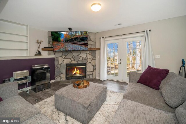 200 Wilderness Ln, Locust Grove, VA 22508 - living room featuring wood finished floors, french doors, built in shelves, and a stone fireplace