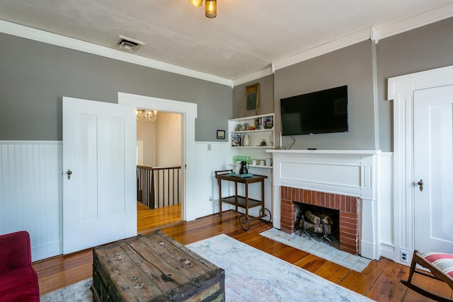 222 Main St, Dayton, VA 22821 - living area with a wainscoted wall, wood-type flooring, a chandelier, a fireplace, and crown molding