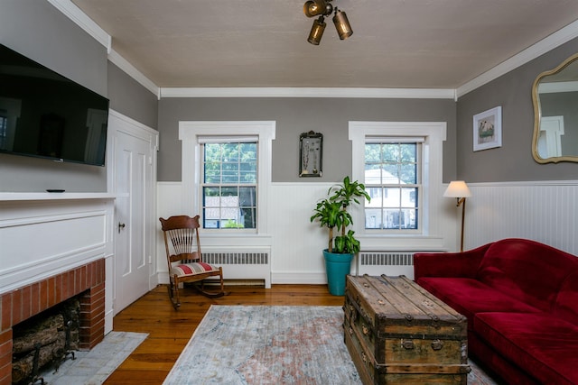 222 Main St, Dayton, VA 22821 - living area featuring radiator heating unit, a wainscoted wall, wood finished floors, and a brick fireplace