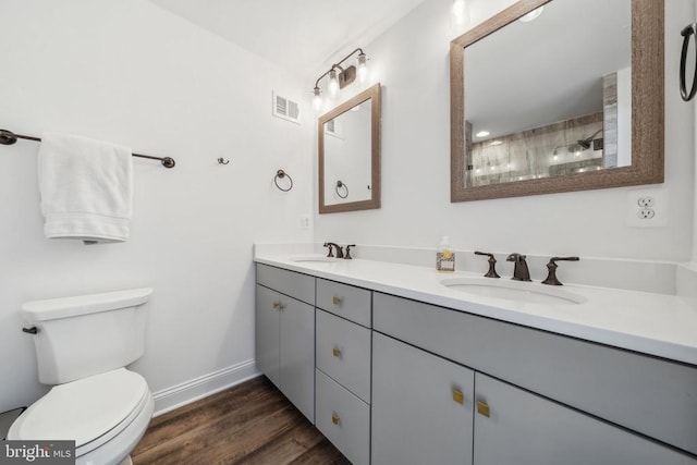 full bathroom featuring toilet, baseboards, wood finished floors, double vanity, and a shower